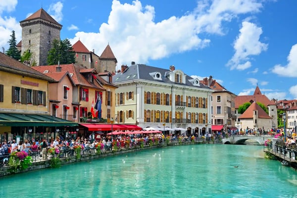 Altstadt von Annecy mit bunten Häusern, Cafés am Kanal, Brücke und historischem Stadtturm