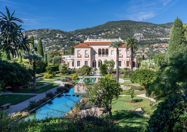 Villa Ephrussi de Rothschild mit Gartenanlage, Wasserbecken und Hügeln im Hintergrund