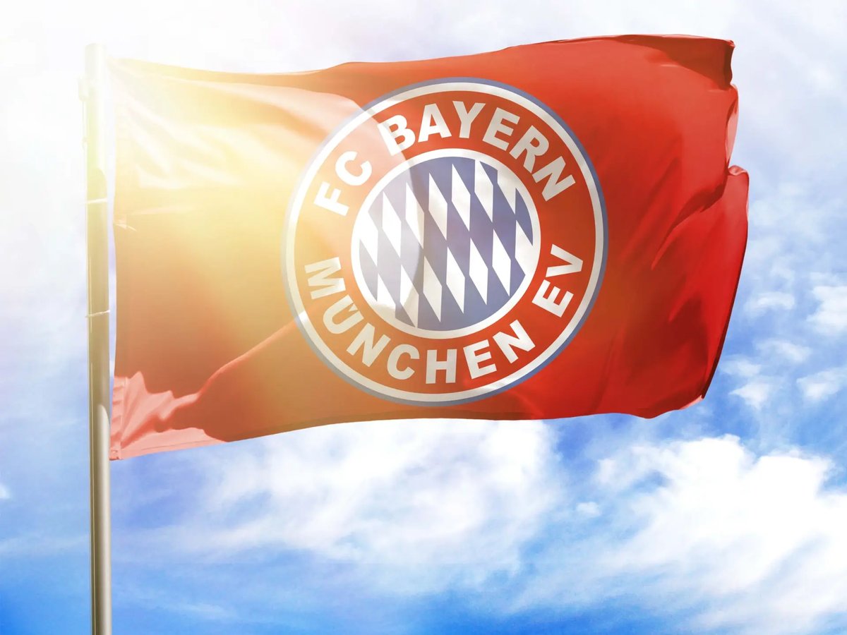 Rote Fahne des FC Bayern München vor blauem Himmel.