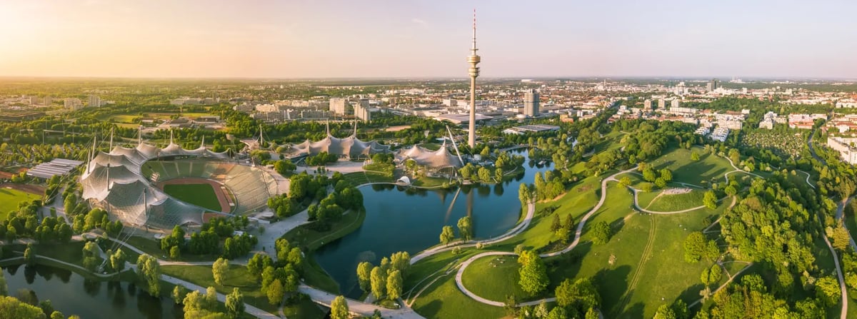 Luftaufnahme des Olympiaparks in München mit Olympiaturm und Stadion.