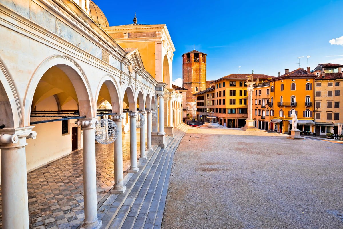 Historischer Platz in Udine mit Arkadengängen, Türmen und farbigen Gebäuden