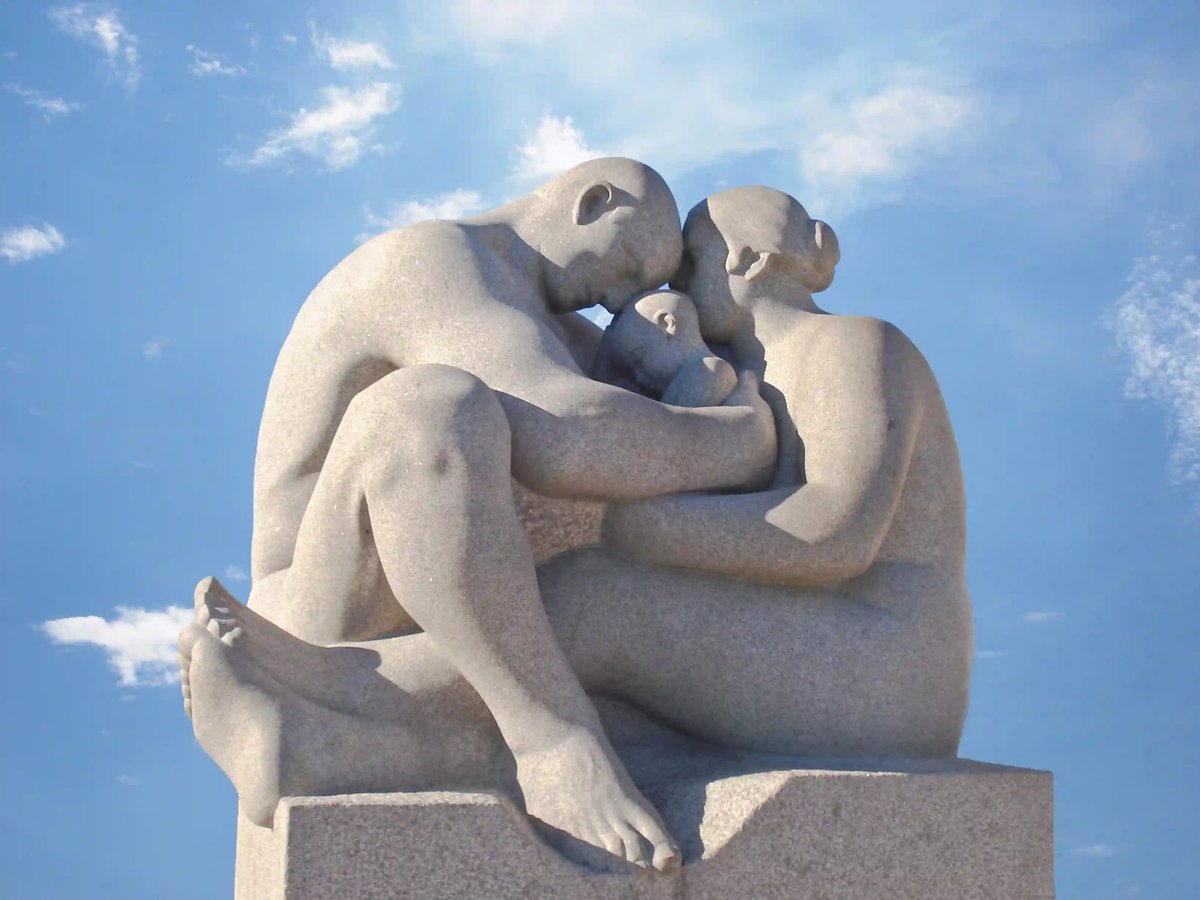 Steinskulptur einer sitzenden Familie im Vigeland Park in Oslo, die Erwachsenen umarmen ein Kind unter freiem Himmel