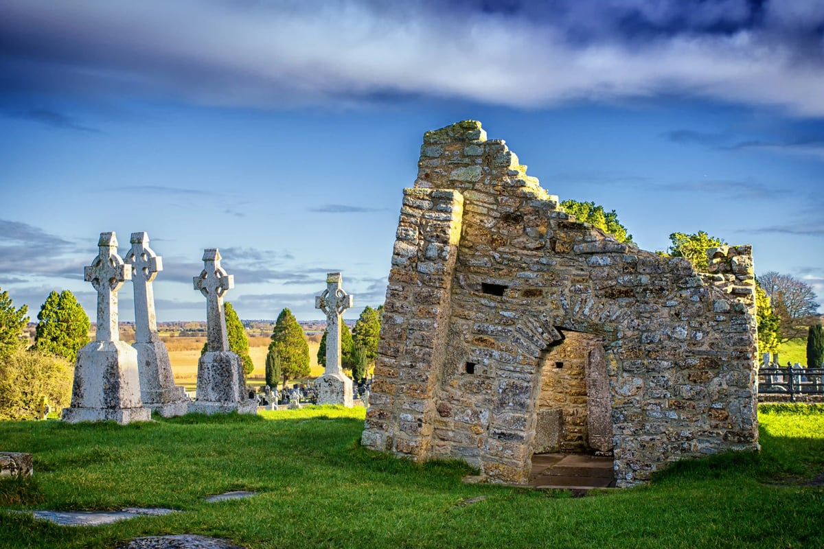 Ruinen der Klostersiedlung Clonmacnoise mit Steinkreuzen, Kapelle und grüner Landschaft