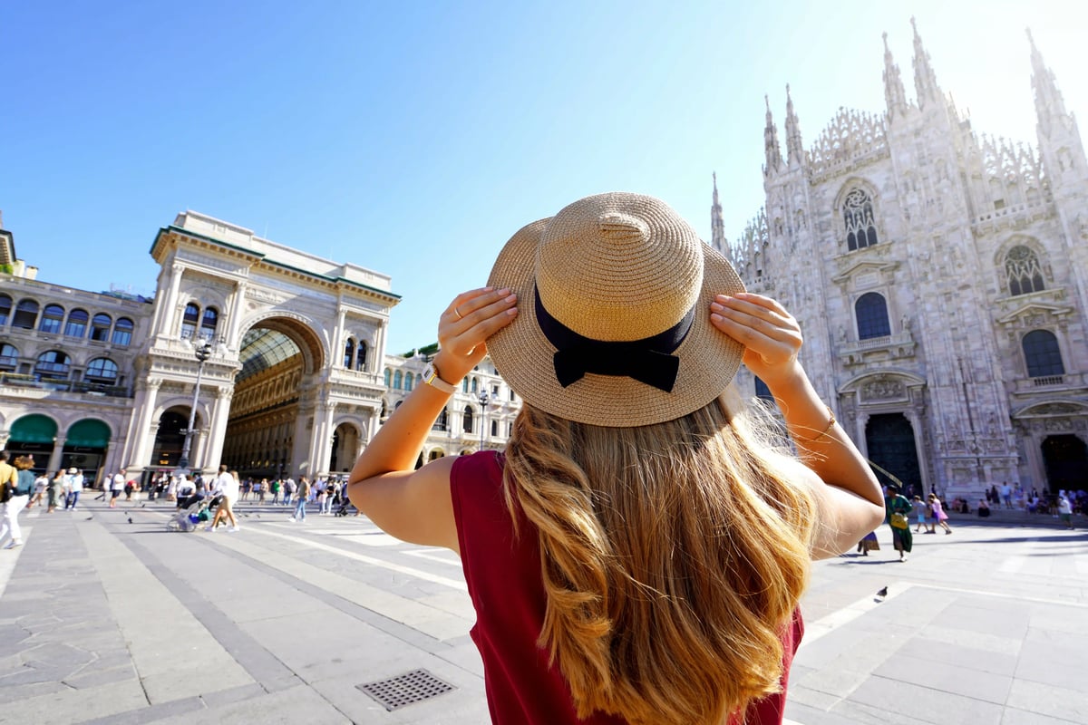 Femme portant un chapeau regardant le Dôme de Milan sur la Piazza del Duomo par temps ensoleillé