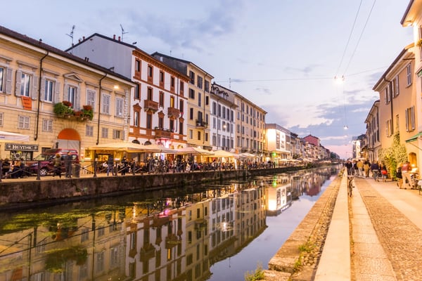 Abendstimmung am Navigli Kanal in Mailand mit beleuchteten Häuserfassaden und Spiegelungen im Wasser