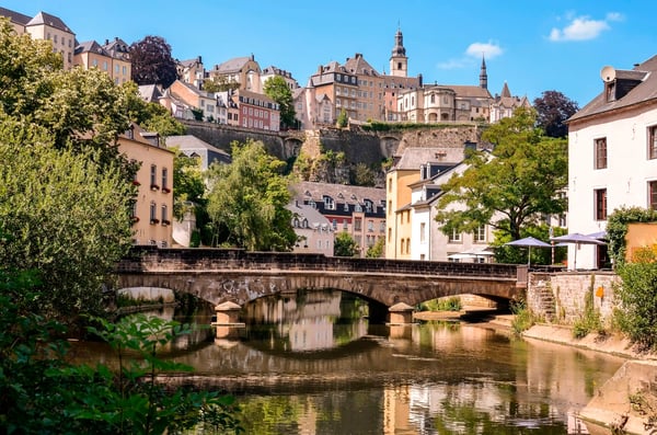 Historische Altstadt von Luxemburg mit Brücke über einem Fluss und Gebäuden auf terrassierten Felswänden