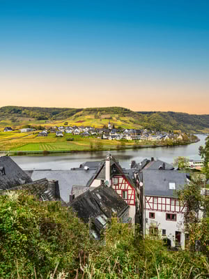 Weitläufige Landschaft an der Mosel mit Weinbergen, Fluss und Ortschaften unter klarem Himmel