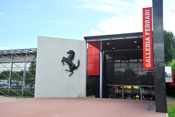Moderner Eingangsbereich des Ferrari Museums mit rotem Schriftzug und schwarzem Pferdelogo
