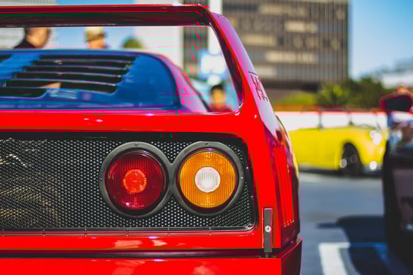 Detailaufnahme der Heckpartie eines klassischen roten Ferrari mit runden Rückleuchten