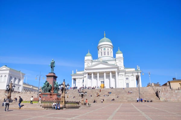 Dom von Helsinki mit weisser Fassade, Treppenanlage und Menschen auf dem Platz