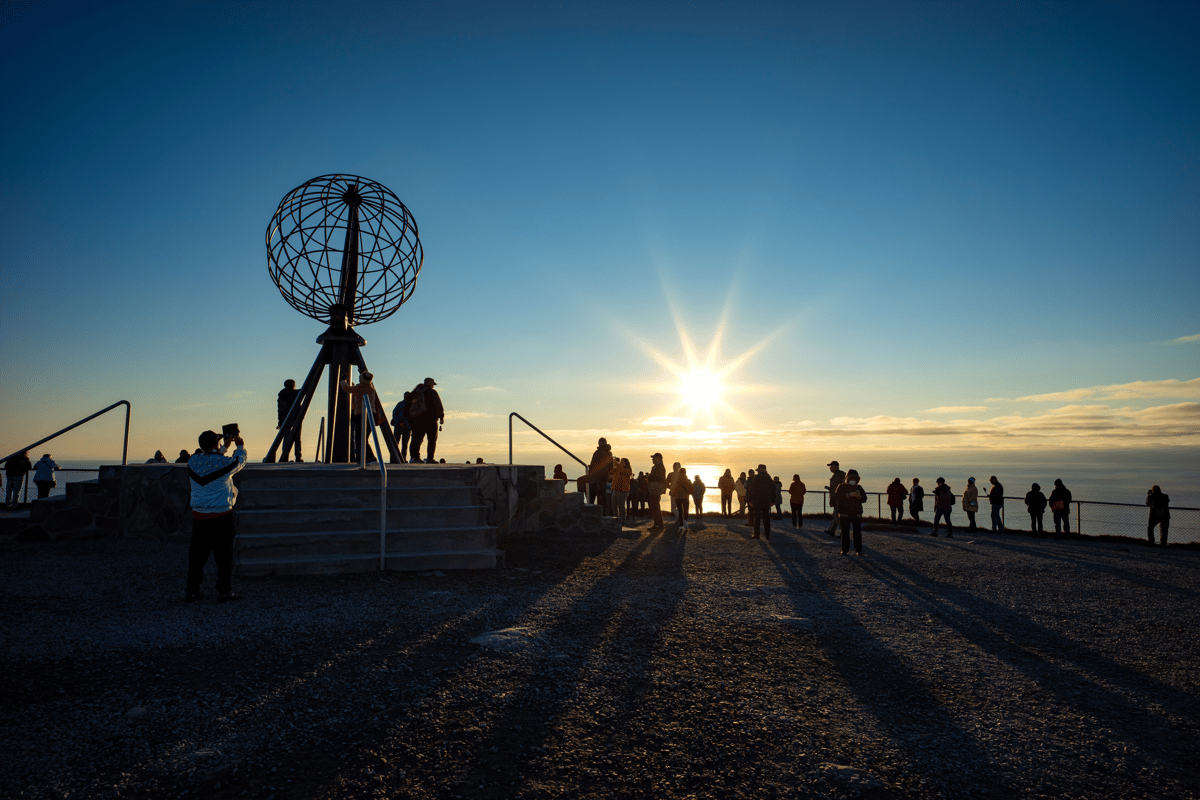 Nordkap mit Globusdenkmal bei Sonnenuntergang über einem Meer aus Wolken