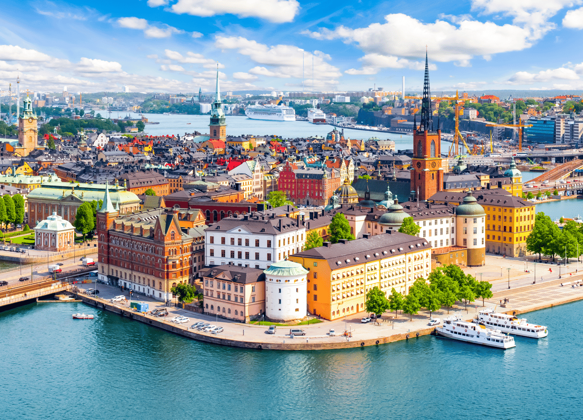 Vue sur la vieille ville de Stockholm avec maisons colorées, clochers et plan d’eau.