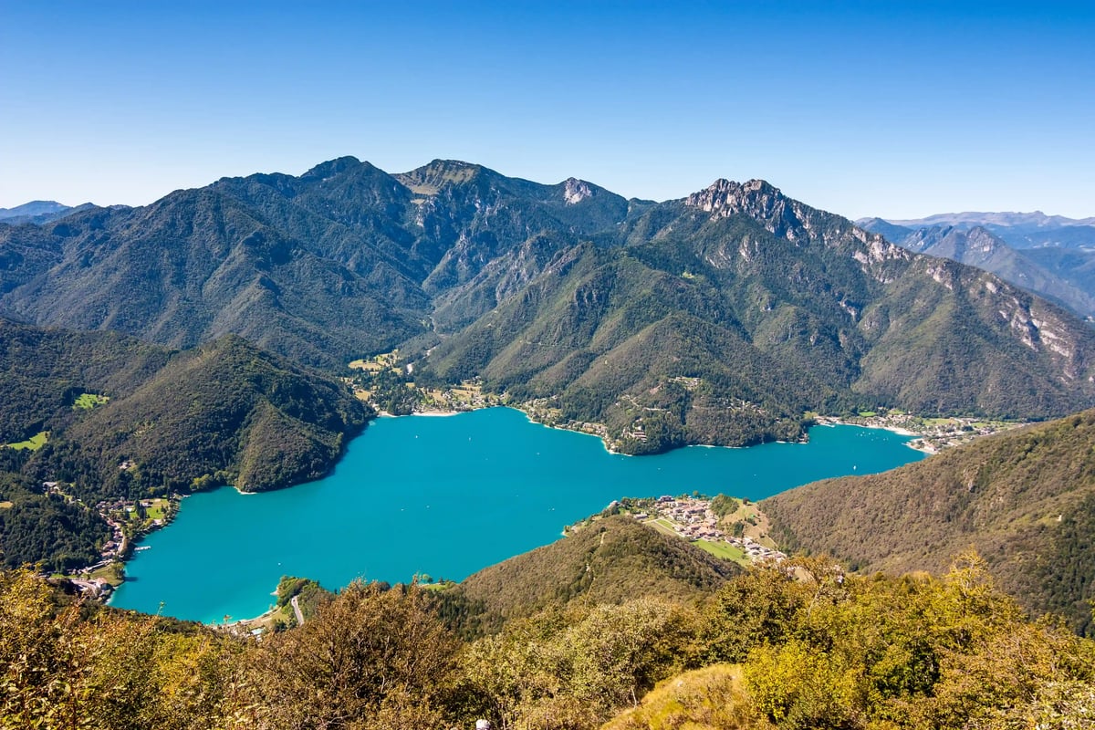 Vue panoramique sur le lac de Ledro aux eaux turquoise entoure de montagnes boisees et de petits villages