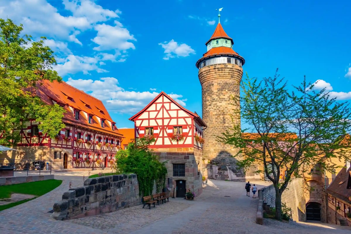 Mittelalterlicher Stadtturm mit Fachwerkhäusern und gepflastertem Weg in historischer Altstadt