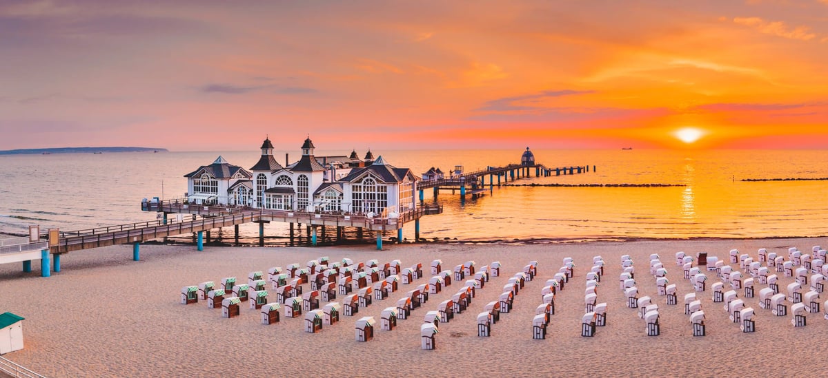 Seebrücke Sellin mit zahlreichen Strandkörben im Vordergrund bei Sonnenuntergang