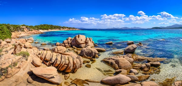 Felsige Küste an der Costa Smeralda mit türkisblauem Meer, Granitfelsen und klarem Himmel