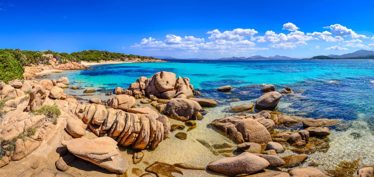 Felsige Küste an der Costa Smeralda mit türkisblauem Meer, Granitfelsen und klarem Himmel