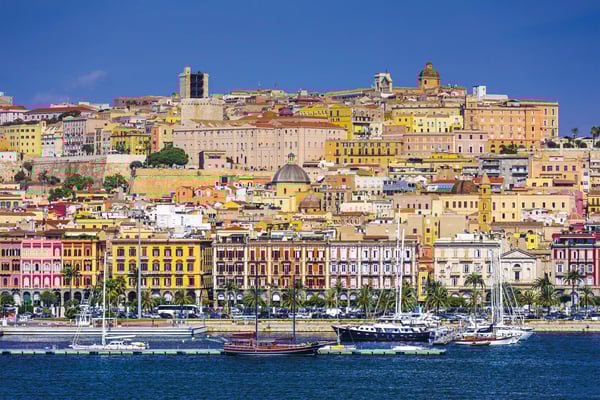 Bunte Häuserfront und Hafen von Cagliari mit Booten und historischer Altstadt