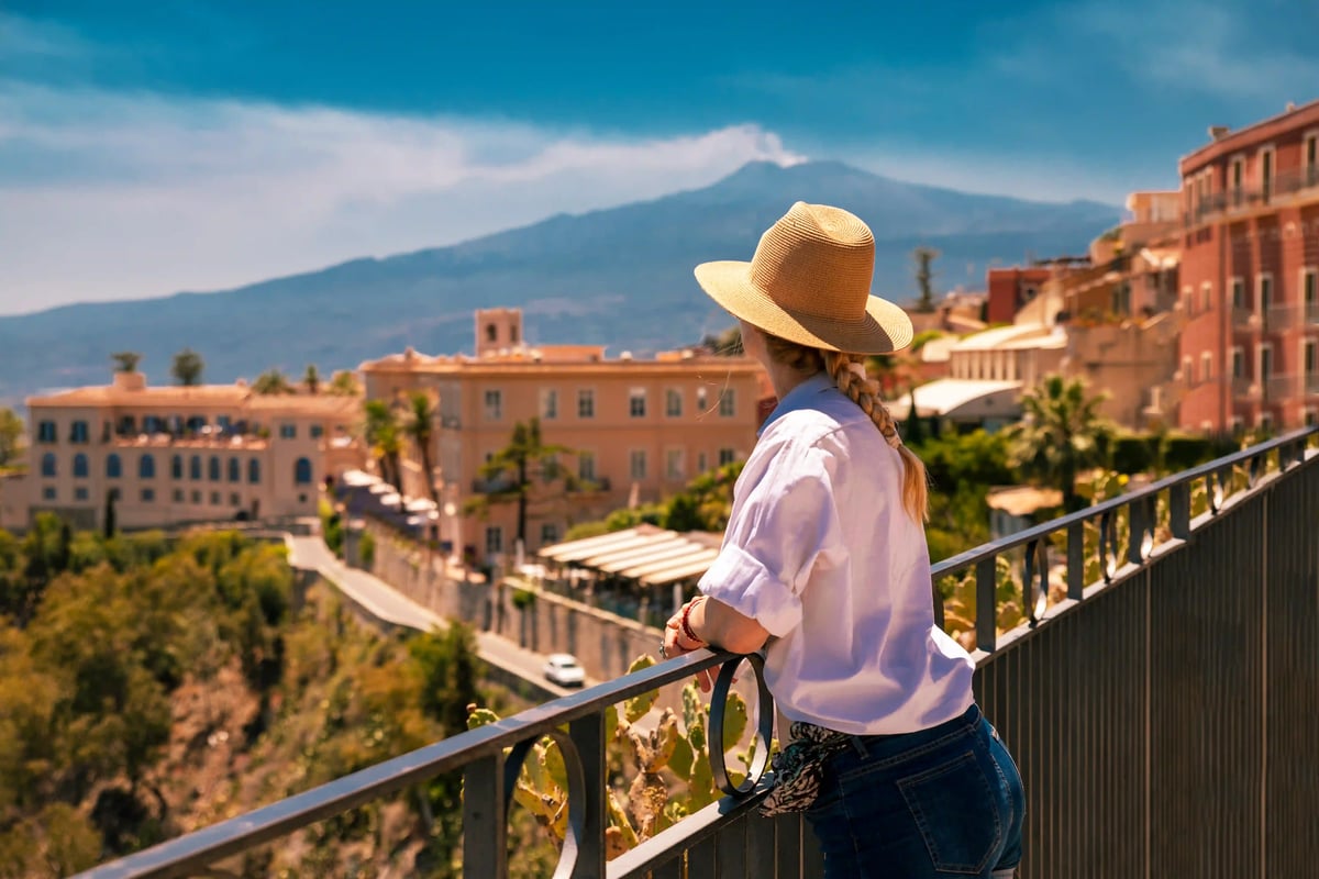 Voyageuse regardant Taormina depuis une terrasse avec l Etna en arrière plan
