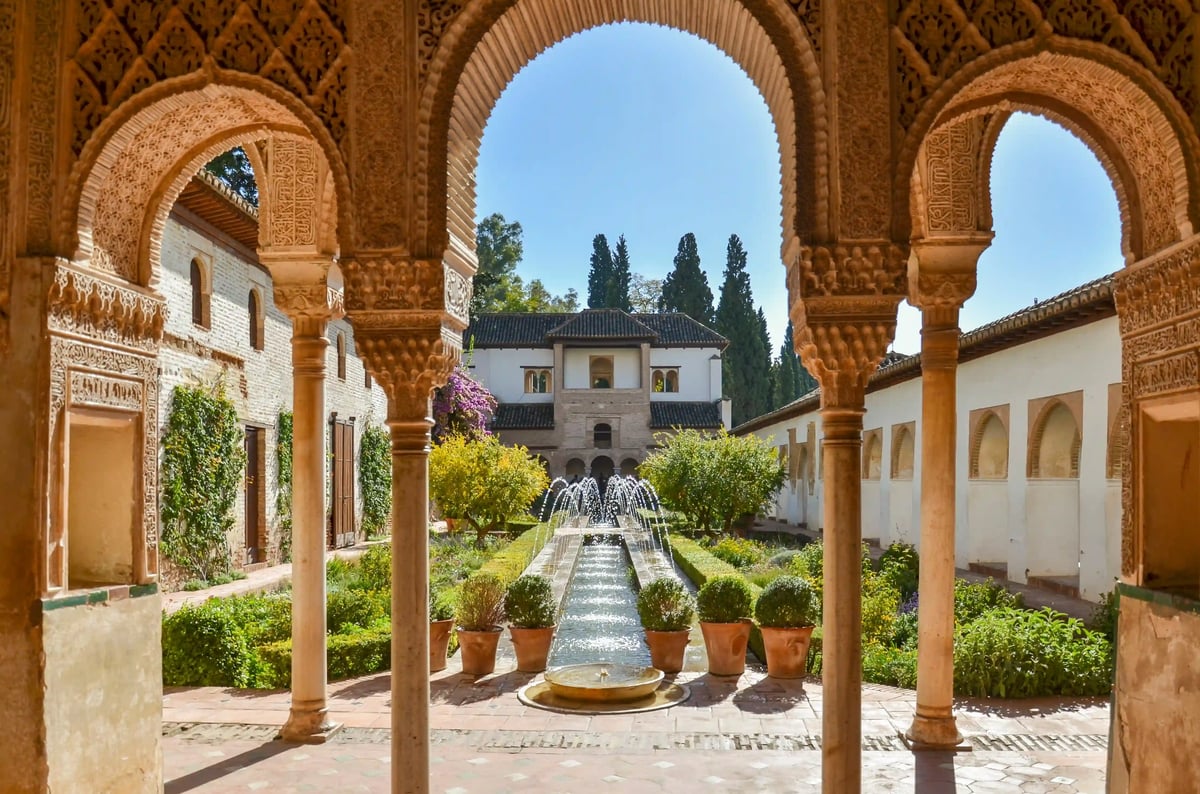 Innenhof der Alhambra in Granada mit kunstvollen Bögen Brunnen und Gartenanlage