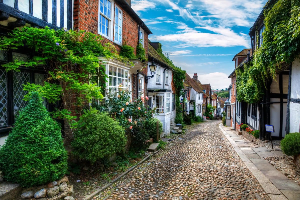 Schmale Kopfsteinpflastergasse in Rye mit historischen Fachwerkhäusern und dichter Begrünung