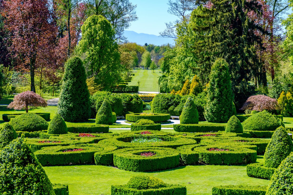 Weitläufiger Tulpenpark mit farbenfrohen Blumenbeeten, gepflegten Hecken und Bergen im Hintergrund