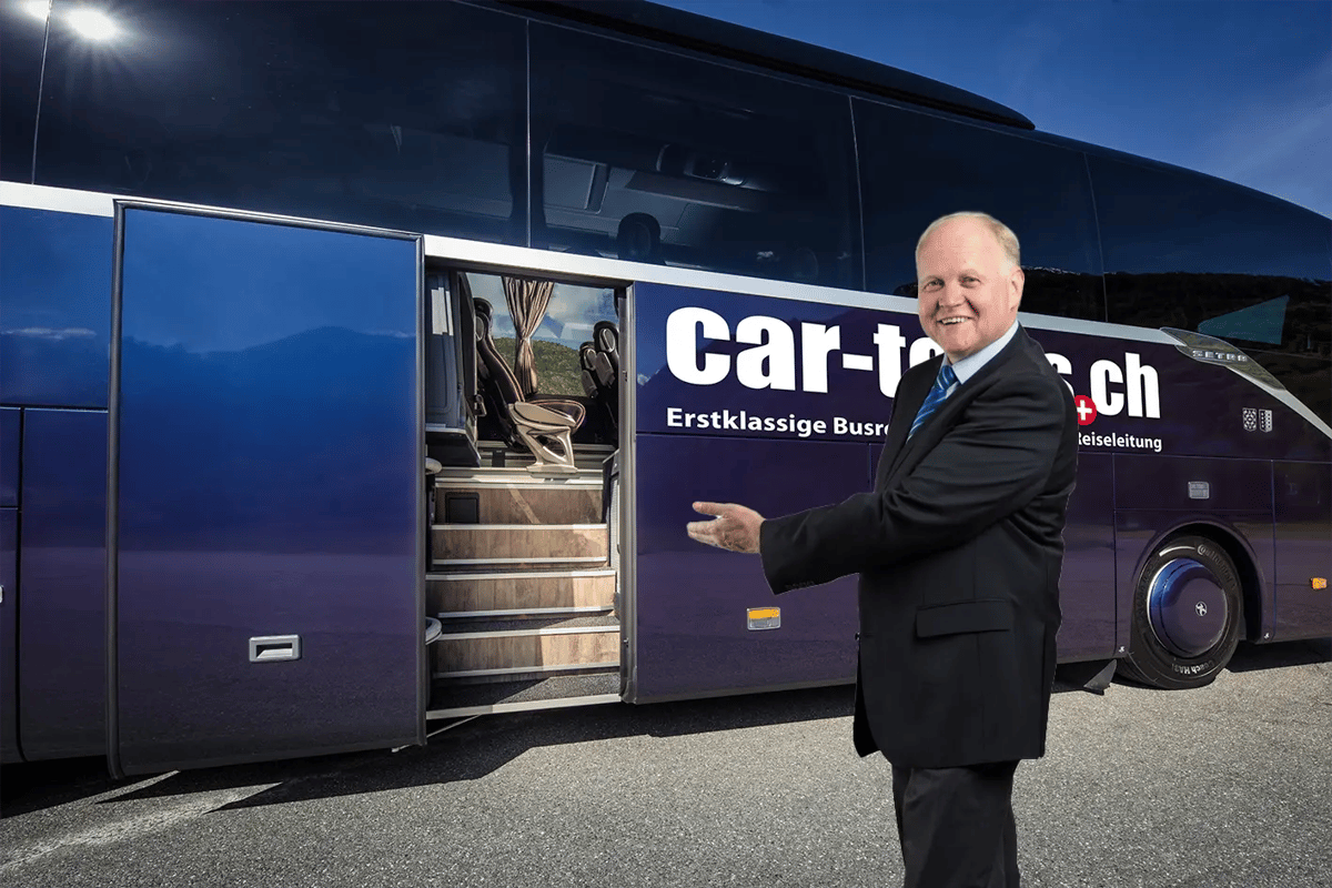 Reiseleiter steht lächelnd vor einem modernen Reisebus und zeigt einladend auf den geöffneten Einstieg mit bequemen Sitzen im Inneren