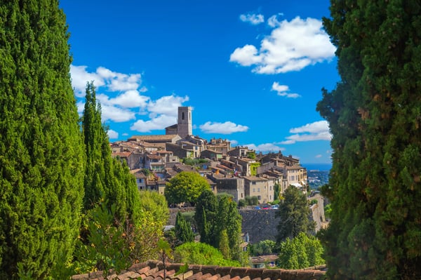 Blick auf das historische Dorf Saint-Paul-de-Vence mit Natursteinhäusern, Kirchturm und mediterraner Vegetation