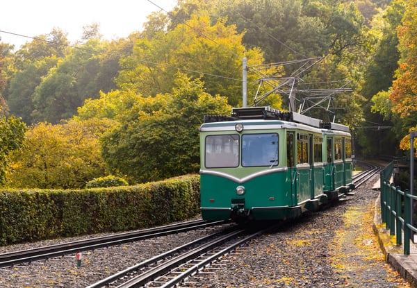 Historische Drachenfelsbahn fährt durch herbstlichen Wald bergauf