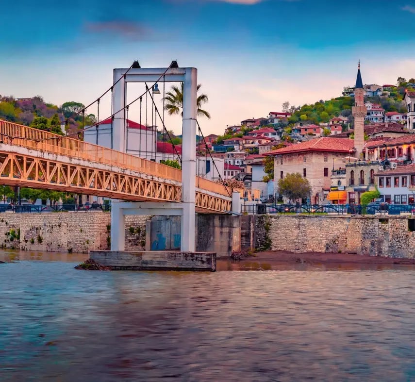 Historische Brücke über den Fluss Osum mit Altstadthäusern und Moschee in Berat.