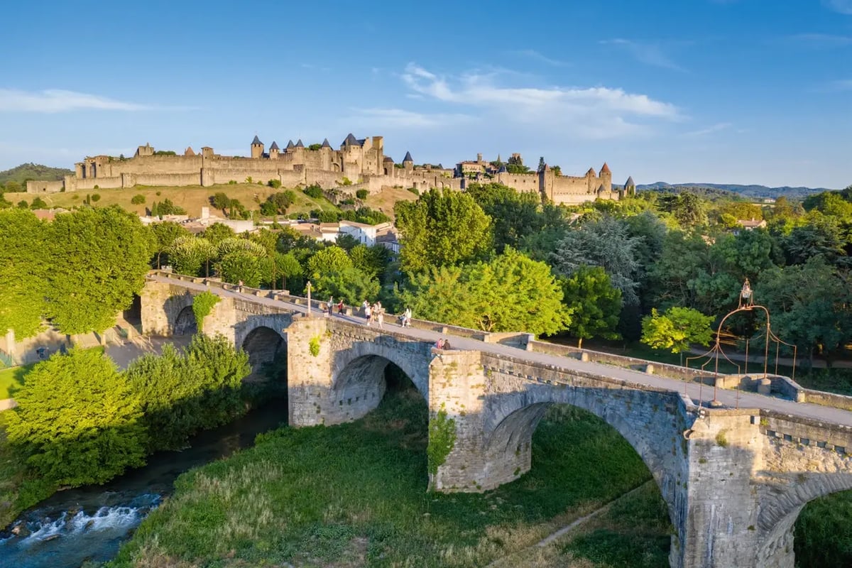 Mittelalterliche Festungsstadt Carcassonne mit historischer Steinbrücke und mächtigen Stadtmauern.