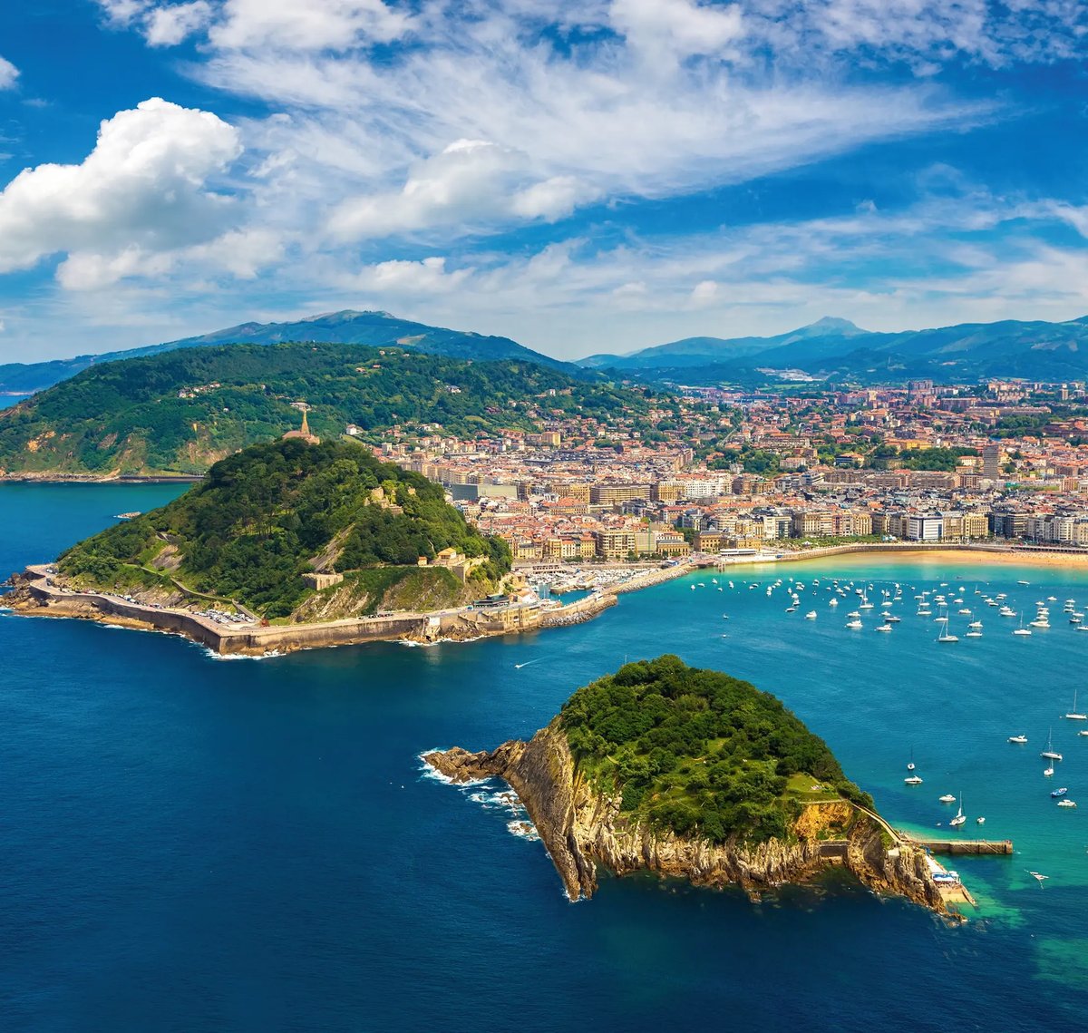 Luftaufnahme der Bucht von San Sebastián mit Inseln, Strand und Küstenpromenade.