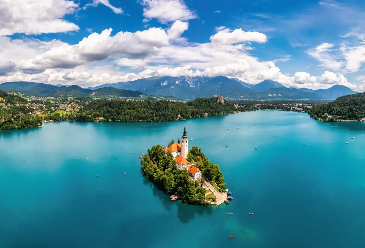 Luftaufnahme der Insel mit Kirche im Bleder See vor den Julischen Alpen.