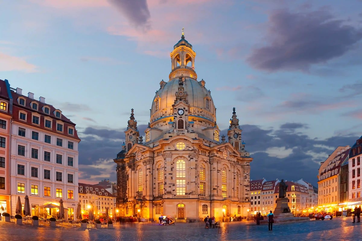 Frauenkirche Dresden in der Abenddämmerung mit beleuchtetem Neumarkt.