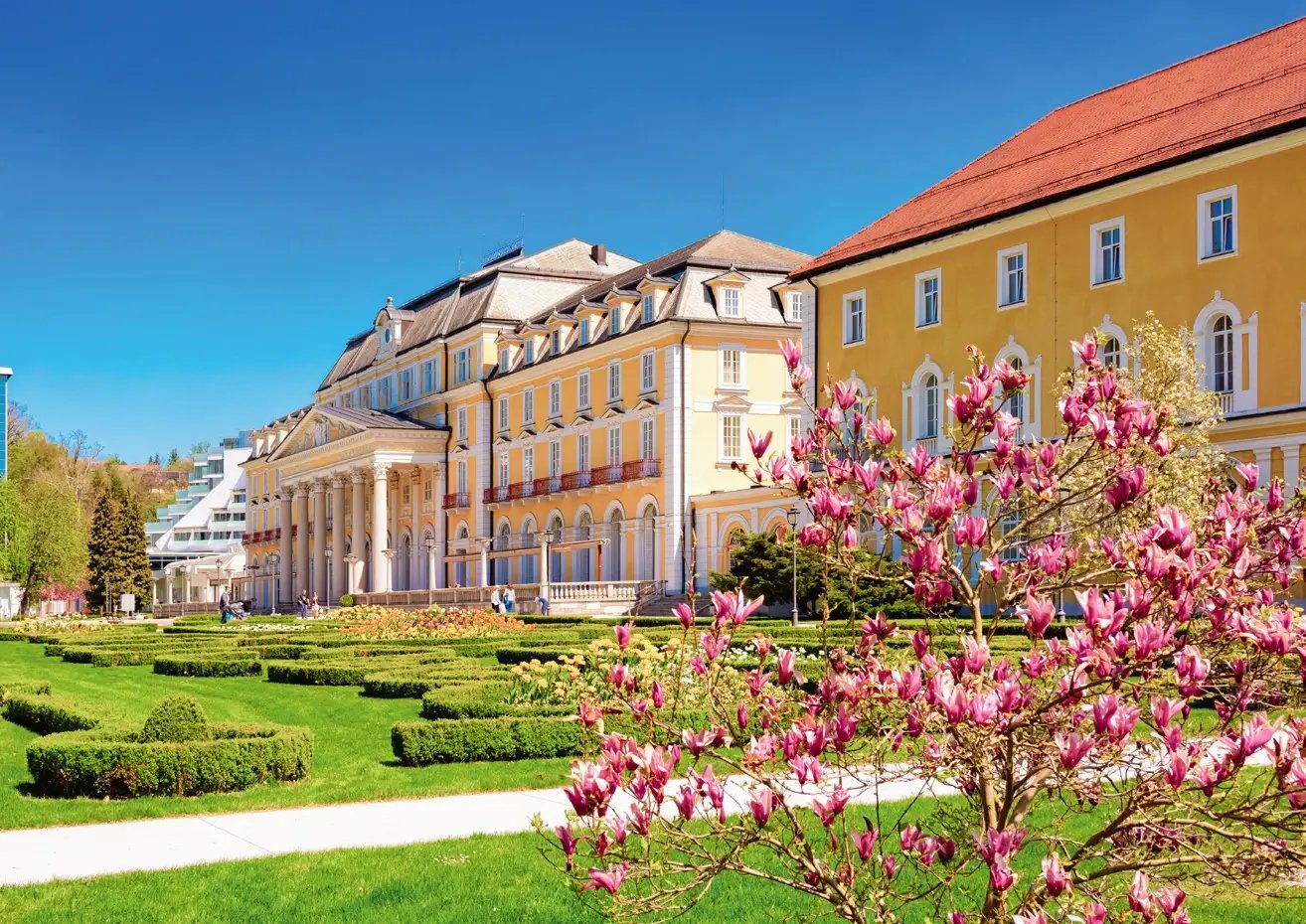Grand Hotel Rogaška mit gepflegtem Park und blühenden Magnolien im Frühling.