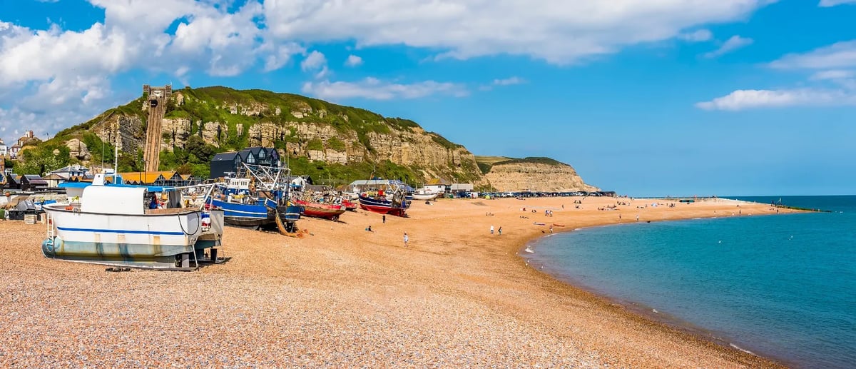 Kiesstrand und Fischerboote im Küstenort Cooden Beach an der Südküste Englands.