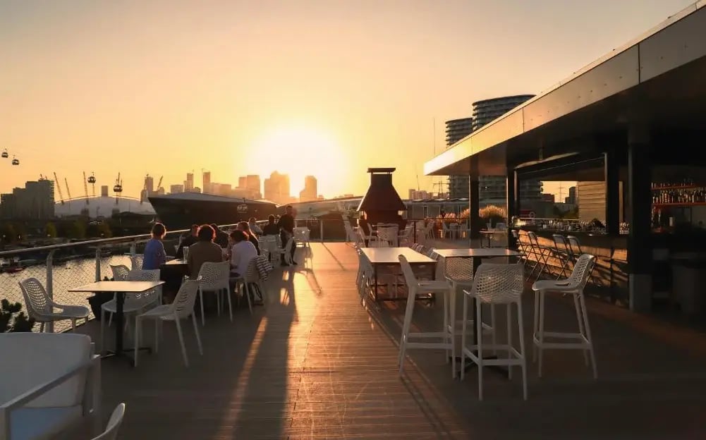 Dachterrasse des Good Hotel London mit Bar und Blick auf die Skyline bei Sonnenuntergang.