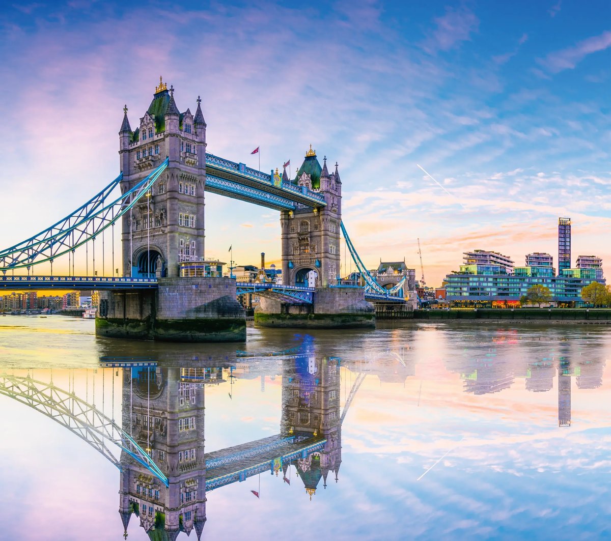 Tower Bridge in London mit Spiegelung auf der Themse in der Abendstimmung.