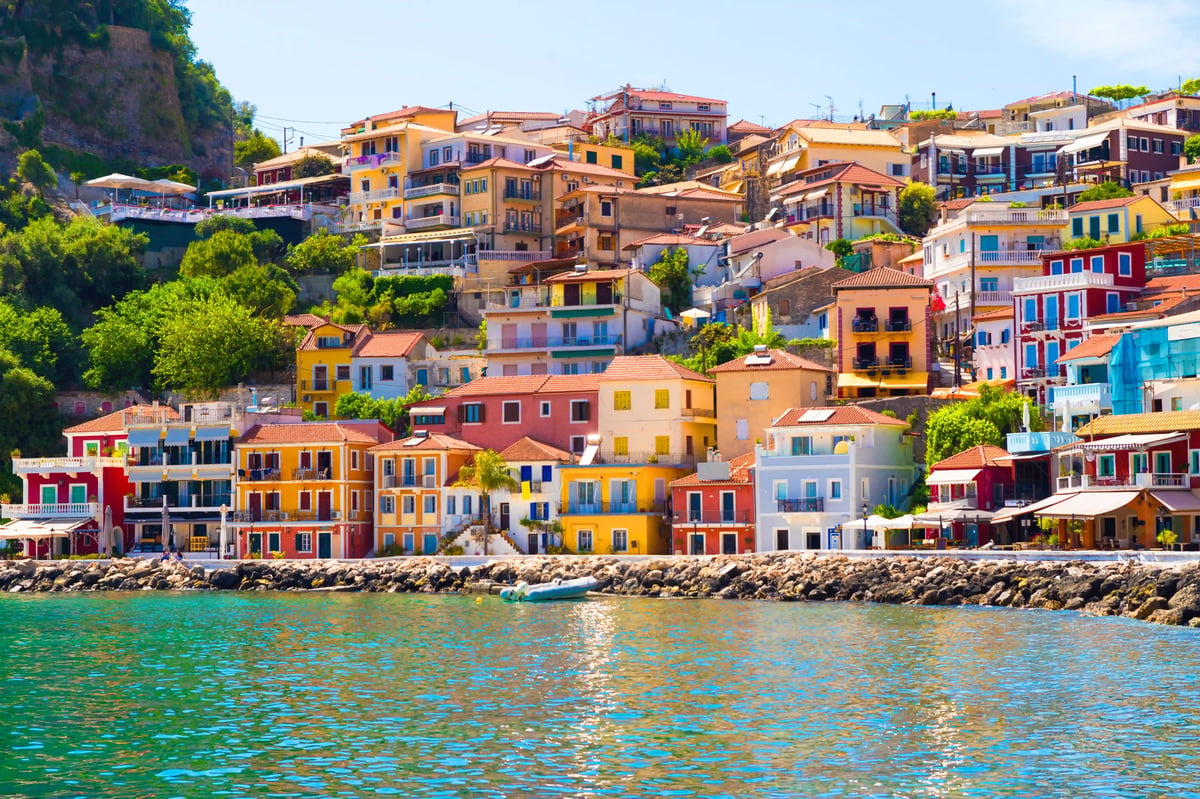Farbenfrohe Häuser von Parga an der Küste mit terrassierter Bebauung und ruhigem Meer
