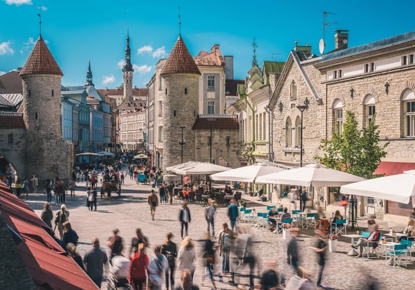 Belebte Gasse in der Altstadt von Tallinn mit historischen Viru Toren, Cafes, Marktständen und vielen Passanten