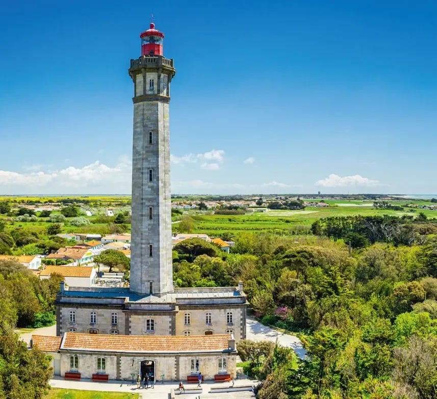 Leuchtturm Phare des Baleines auf der Île de Ré mit Blick über Wälder und Küstenlandschaft.