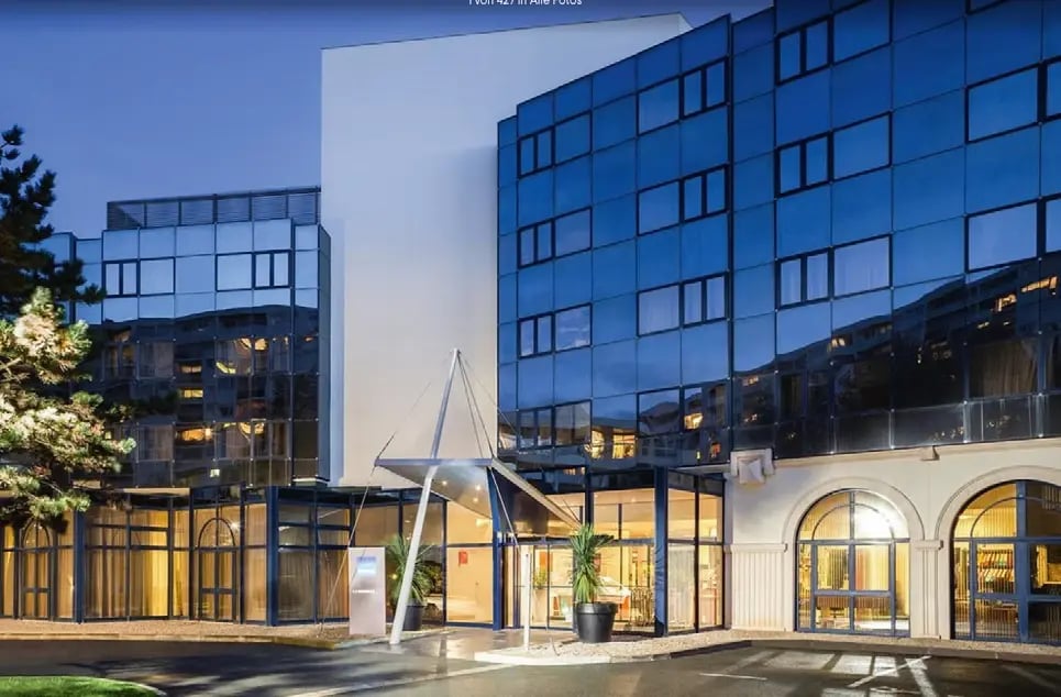 Modernes Hotel Novotel La Rochelle mit beleuchtetem Eingangsbereich am Abend.
