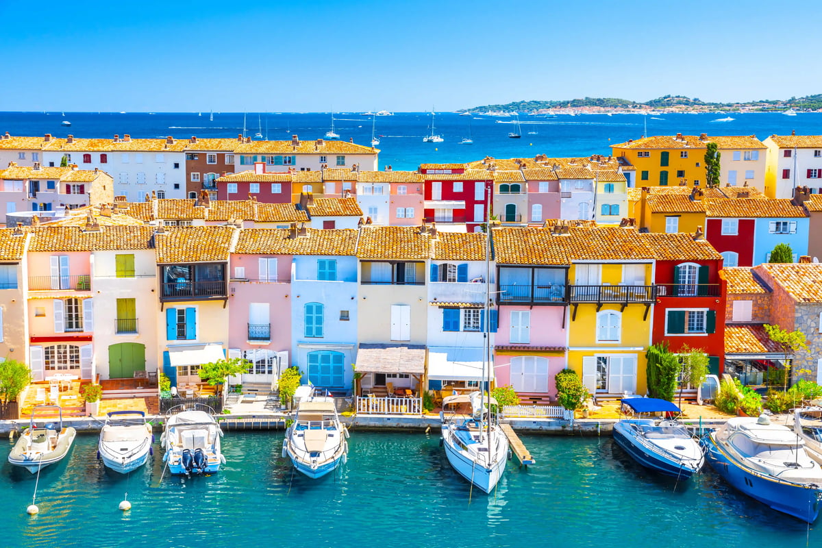 Bunte Häuser von Port Grimaud mit Booten an kleinen Anlegestellen und ruhigem Wasser