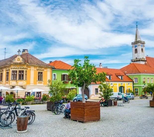 Historischer Hauptplatz von Rust mit bunten Bürgerhäusern und Kirchturm.
