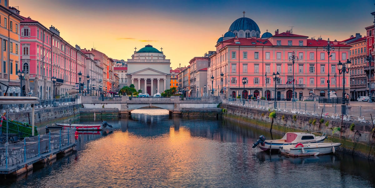 Canal Grande in Triest mit Brücke, historischen Palästen und Booten bei Sonnenuntergang