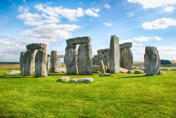 Steinkreis von Stonehenge auf einer offenen Grünfläche bei blauem Himmel