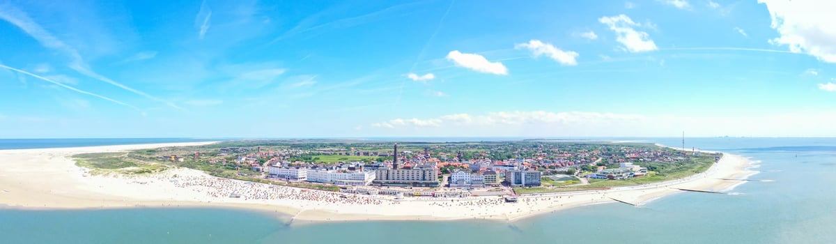 Panoramablick auf Borkum mit breitem Sandstrand und Nordseeküste.