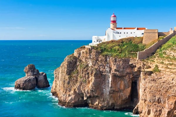 Leuchtturm am Cabo Sao Vicente auf einer steilen Felsklippe mit Blick auf den Atlantischen Ozean