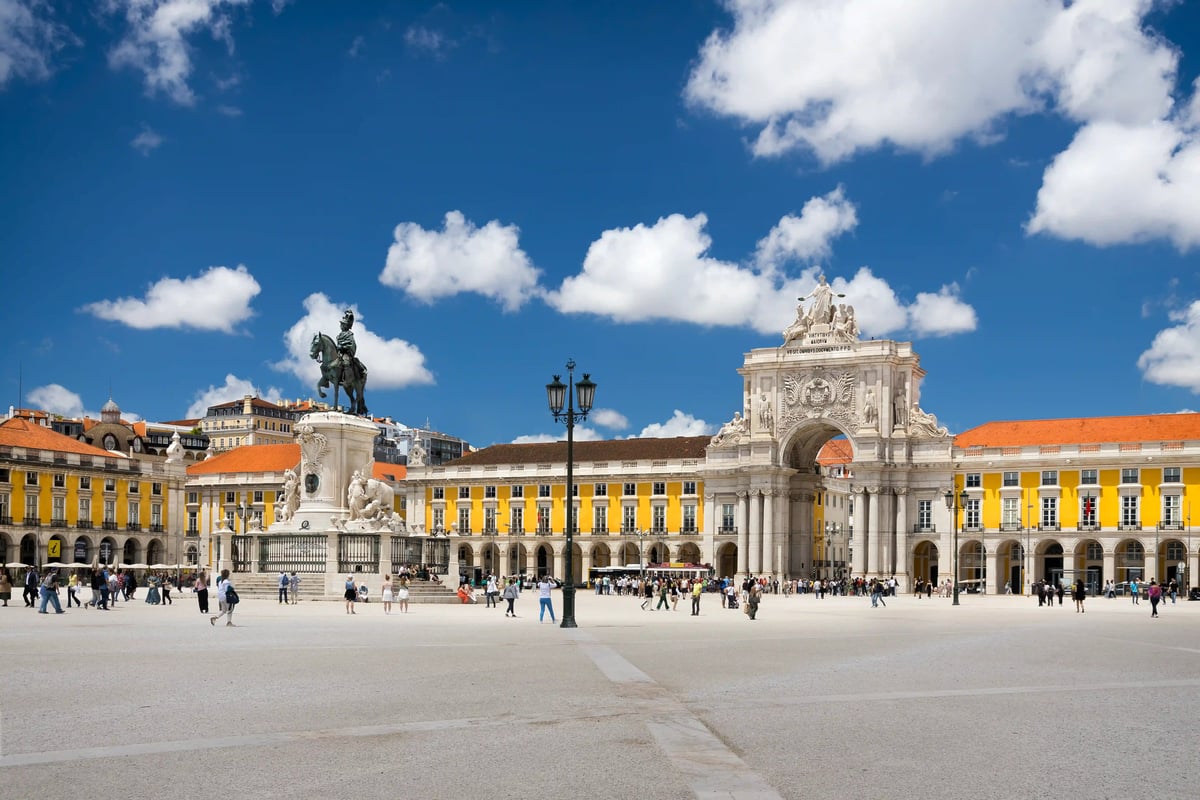 Praca do Comercio in Lissabon mit Triumphbogen, Reiterstatue und Besucherinnen und Besuchern