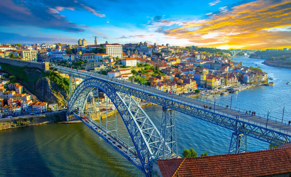 Panoramablick auf Porto mit Dom Luis Brücke über den Douro Fluss bei Sonnenuntergang